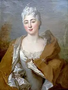 Aïssé in a white silk and lace dress, wrapped in a brown cloak lined with white silk, with a sprig of flowers and a pearl in her powdered hair