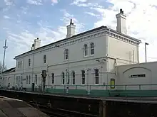 Platform-side view of the main building from rail height, standing on the adjacent level crossing