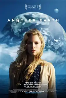A blonde young woman from the waist up, standing in front of a sea and Earth.