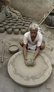 Image 14PotterPhoto: YannA potter at work in Jaura, Madhya Pradesh, India. Pottery, defined by ASTM International as "all fired ceramic wares that contain clay when formed, except technical, structural, and refractory products", originated during the Neolithic period.More selected pictures