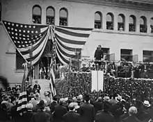 Theodore Roosevelt speaking on platform in front of Pearsons Hall to dense crowd