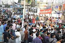 Large crowd (mostly male) with banners in street