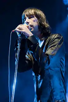 Colour photograph of Bobby Gillespie singing live in 2009