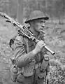 Private H.E. Goddard of The Perth Regiment, carrying a Bren gun while advancing through a forest north of Arnhem, Netherlands, April 1945