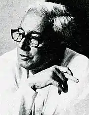 Promode Dasgupta holding a cigar between his fingers
