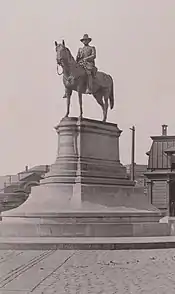 A sepia photograph of a monument consisting of an equestrian statue atop a large pedestal