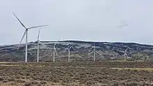 Wind turbines in the foreground with the Pryor Mountains in the background.