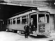 New Orleans Public Service's Prytania streetcar line, 1907. Two uniformed men stand by entrance, presumably the motorman and the conductor. Streetcar is probably at Prytania Station carbarn.