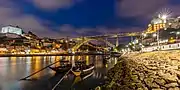 Night view of the bridge showing the historic centre of Porto and main archway.