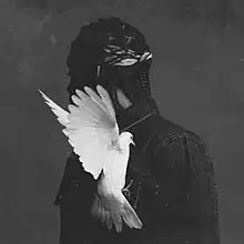 A grayscale photo of Pusha T, with his head turned away and a white pigeon clinging to his chest.