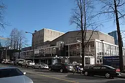 A modern theatre building in off-white concrete, glass facade for the first three storeys