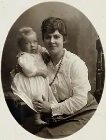 A young, brown-haired woman holding a baby.