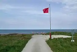 A red flag flying on a cliff edge with the North Sea beyond