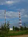Lattice steel telecommunication tower (right); original mast (left)