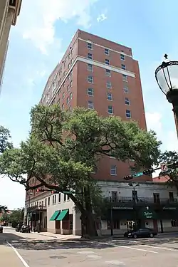 Ground-level view of a 12-story building with a red brick facade.