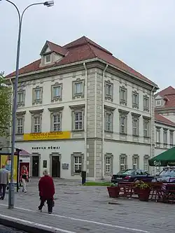 Three story building with a red roof.