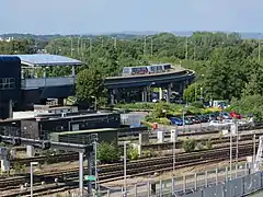 Shuttle Transit station and train at South Terminal in 2016 with railway tracks in foreground