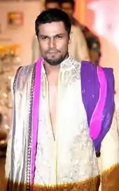 Hooda walking the ramp wearing a golden sherwani.