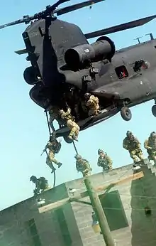 Rangers practice fast roping techniques from an MH-47 during an exercise at Fort Liberty, 28 April 2010