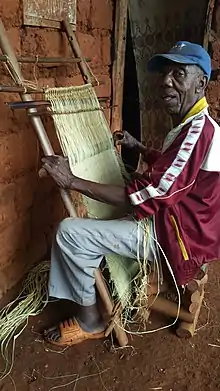 Weaving raffia on an upright loom in Babouantou, Cameroon.