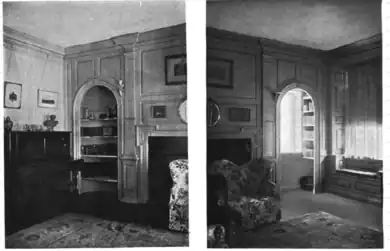 interior of a house with fireplace, paneling, and an arched window