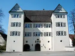 A large white building with two wings and a black roof