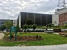 A park with chairs fronting a library in a downtown area