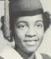 A smiling young Black woman wearing an academic cap and gown