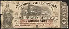 Two dollar note. Illustrated with a woman on the left and a train in the middle. Inscribed text reads  "RECEIVABLE in payment of all dues to the Co. January 1st, 1862. THE MISSISSIPPI CENTRAL RAIL-ROAD COMPANY Will pay to bearer TWO DOLLARS in current, Bank or Confederate State notes, when the sum of Five dol is presented. HOLLY SPRINGS, MISS."
