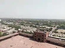 Image shows Red Fort's long walls including the gates as seen from Jama Masjid's tower. The walls can be seen in the background extending a couple of thousand meters.