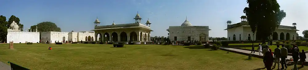 Many white buildings, with large grassy area in foreground