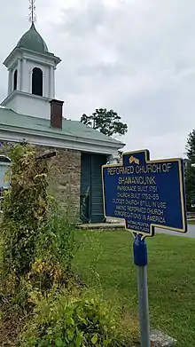 a picture of the marker with the church and low steeple behind it