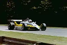 Frontview of a yellow-and-white Renault racing car during a race