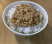 This food is white rice served in a bowl with natto (fermented soybeans) on top