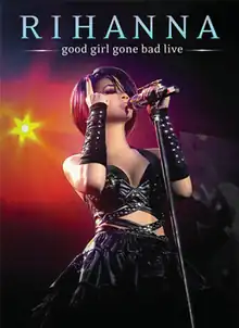 The front full body profile of a dark haired female standing singing into a microphone stand. Her eyes are closed and heavily shadowed in black eye make up. Her fringe covers the left side of her face. She is pointing her right index finger upward. On her forearms are long black strap pieces spiked with silver metal. She is wearing a revealing leather dress outfit. In her background is sun-like coloured lighting. At the top of the portrait stands 'Rihanna' and below it 'Good Girl Gone Bad Live'.