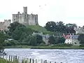 The castle stands on a hill above the village and river.