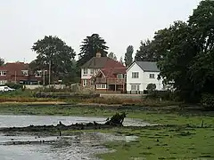 View of river shore and houses in background