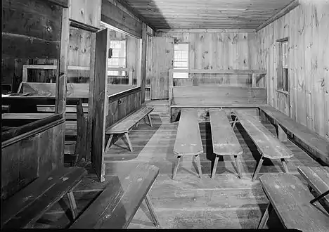 Women's meeting for business. Facing benches center, fully open partition on left