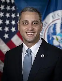 Portrait of Robert Silvers with American flag on left and Department of Homeland Security flag on right