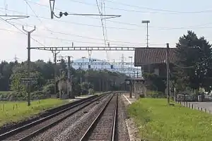 Double-tracked railway line with two-story station building on the right