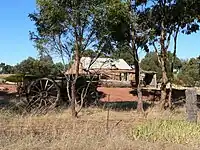 The restored cottage of the Rosenzweig's at Moculta, built circa 1859 with farm equipment in the foreground.
