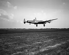 Avro Lancaster B.3, ED831 'WS-H', of No. 9 Squadron taking off at RAF Bardney, Lincolnshire, for a raid on the Zeppelin works at Friedrichshafen in Germany.