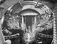 Interior of a glider with men sitting in rows along both sides