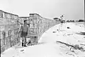 A wind break constructed from ration boxes protects the small RAF camp at Kelai, Maldive Islands, which serves as a refuelling base for flying boats operating in the Indian Ocean.