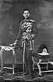 King Prajadhipok in the scarlet uniform, with the old style helmet to the right of the picture