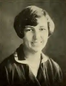 A smiling young white woman with hair in a side-parted bobbed style