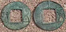 Two green coins with square holes
