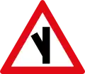 Skewed side road junction ahead to left