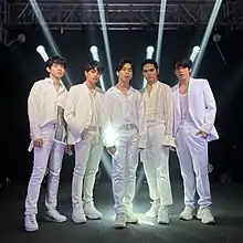 An image of SB19 posing, each wearing all-white clothing.