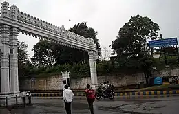 Large, rectangular stone arch, with pedestrians and motorcyclists
